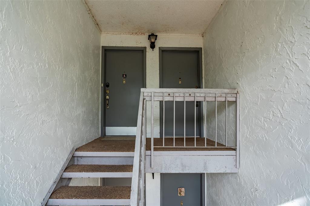 A living room features a tan sofa, a patterned area rug, and a sliding glass door — 2746 SW 14 DRIVE UNIT 2746, GAINESVILLE, FL