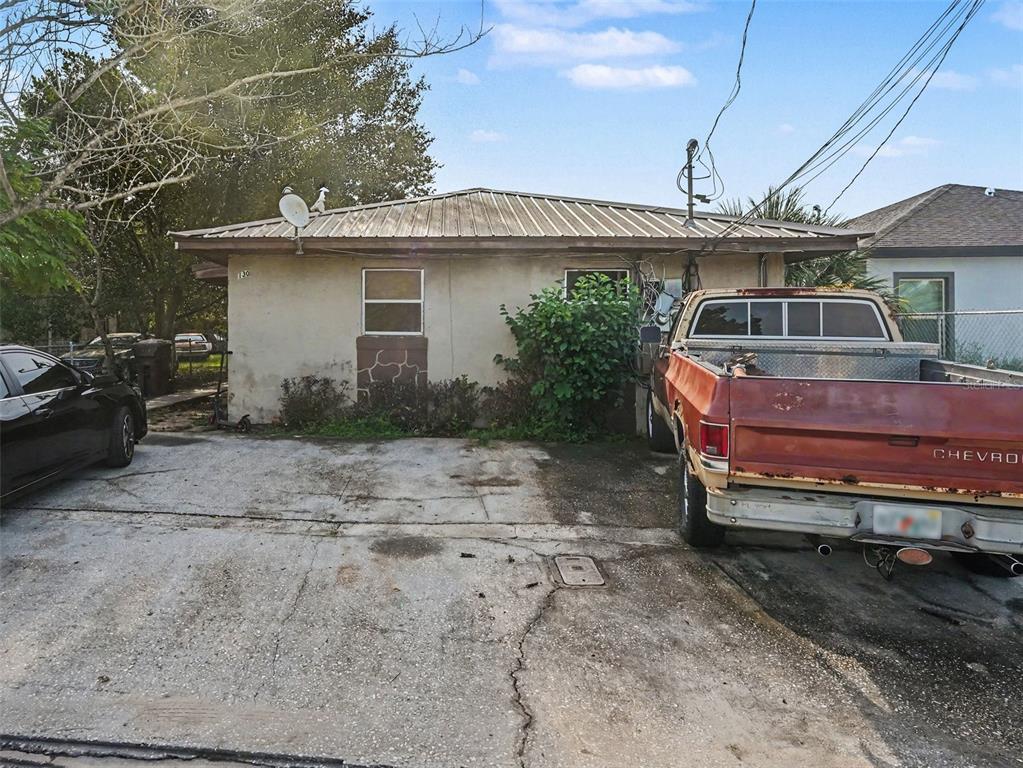 A single-story house with a metal roof, concrete driveway, and a parked pickup truck — 130 D STREET UNIT 1,2,3,4, LAKE WALES, FL
