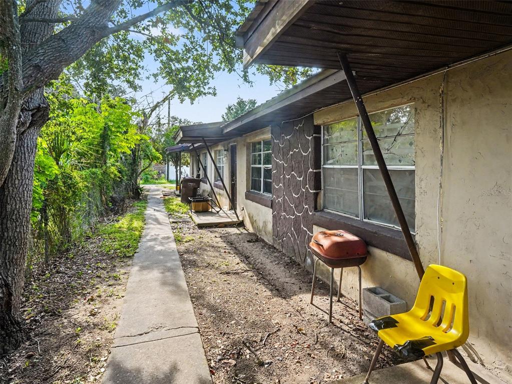 A narrow concrete walkway runs alongside the exterior wall of a single-story residential building — 130 D STREET UNIT 1,2,3,4, LAKE WALES, FL
