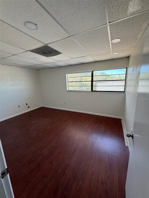 An empty room features wood-look flooring, white walls, and a drop ceiling with recessed lighting — 254 S RONALD REAGAN BOULEVARD UNIT 132, LONGWOOD, FL