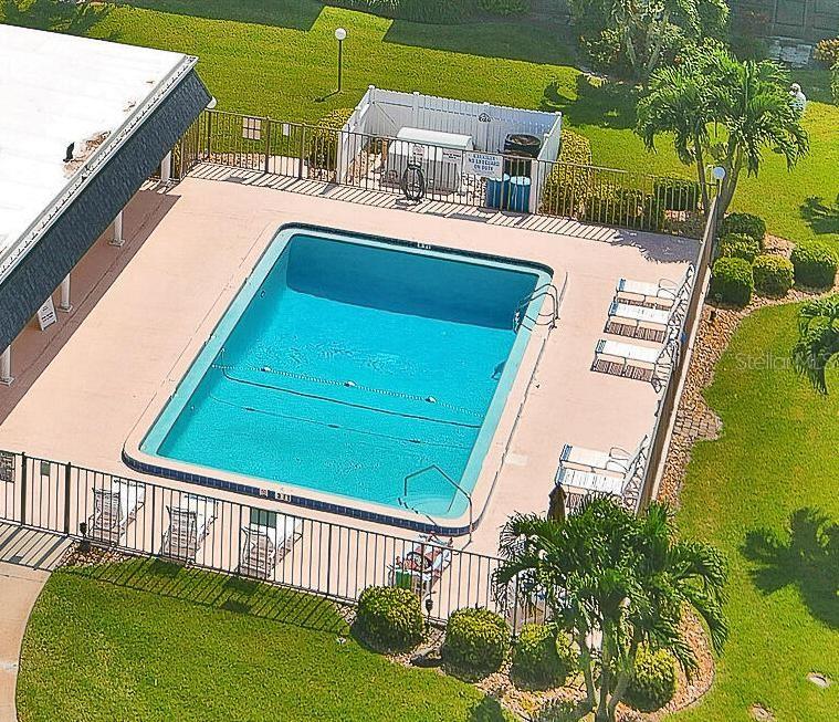 An aerial view shows a rectangular swimming pool surrounded by a patio and lounge chairs — 3799 S BANANA RIVER BOULEVARD UNIT 823, COCOA BEACH, FL