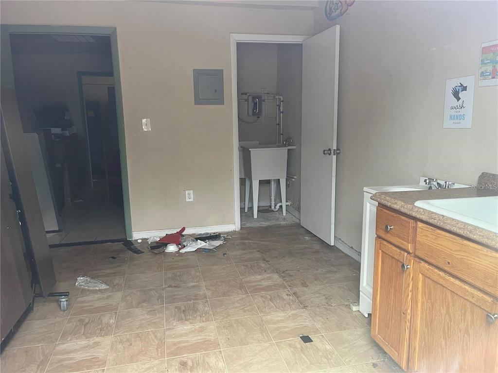 A room with tile flooring, a utility sink in a closet, and a wooden vanity — 2222 E DR MARTIN LUTHER KING JR BOULEVARD, TAMPA, FL