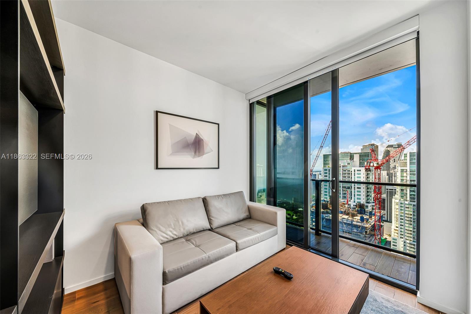 A modern living room features a grey sofa, wood coffee table, and a balcony with city views — 398 NE 5 # 4416, Miami FL 33132, MIAMI, FL