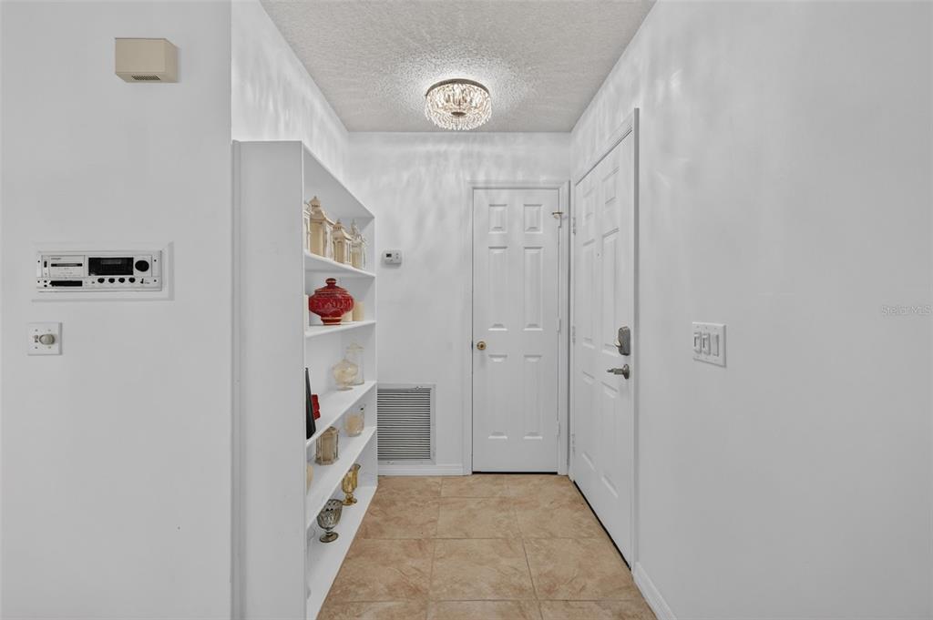A tiled entryway features a white built-in shelving unit, a ceiling light, and two doors — 954 AVALON AVENUE, LADY LAKE, FL