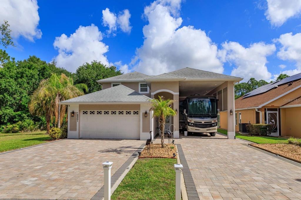 A two-story house features a garage, a large attached RV carport, and a paved driveway — 16201 CITRUS PKWY, CLERMONT, FL