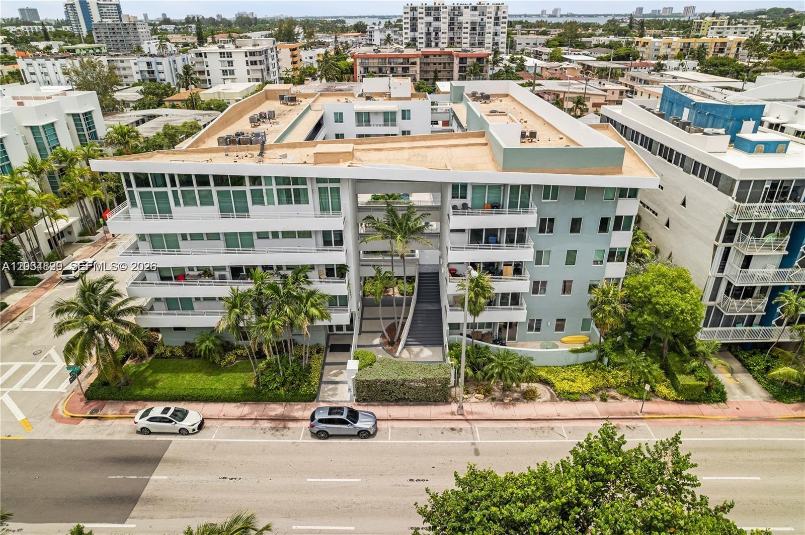An exterior view of a multi-story apartment building with a central courtyard and palm trees — 7800 Collins Ave # 508, Miami Beach FL 33141, MIAMI BEACH, FL