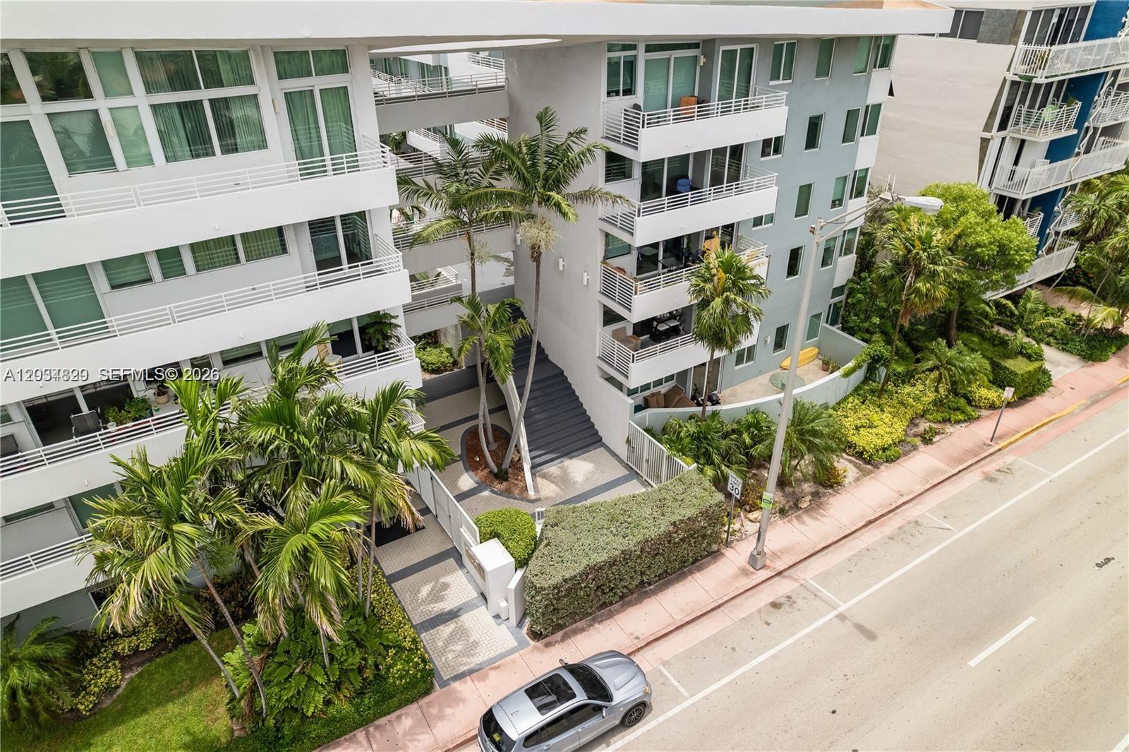 An aerial view shows the exterior of a multi-story apartment building with palm trees — 7800 Collins Ave # 508, Miami Beach FL 33141, MIAMI BEACH, FL