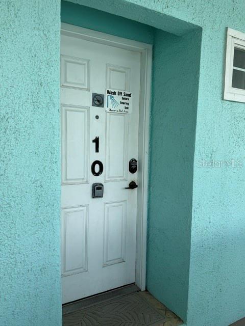 A white door with the number 10 is set into a light blue stucco wall — 301 S CENTRAL AVENUE UNIT 10, FLAGLER BEACH, FL
