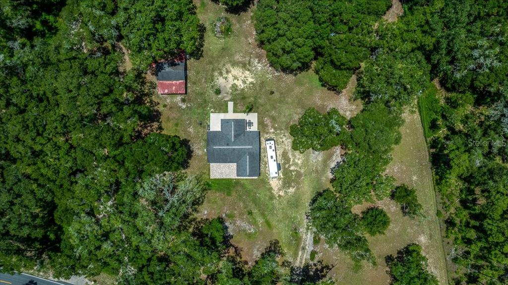 An aerial view shows a house, a detached shed, and a trailer on a wooded lot — 6150 S HIGHWAY 314A, OCKLAWAHA, FL