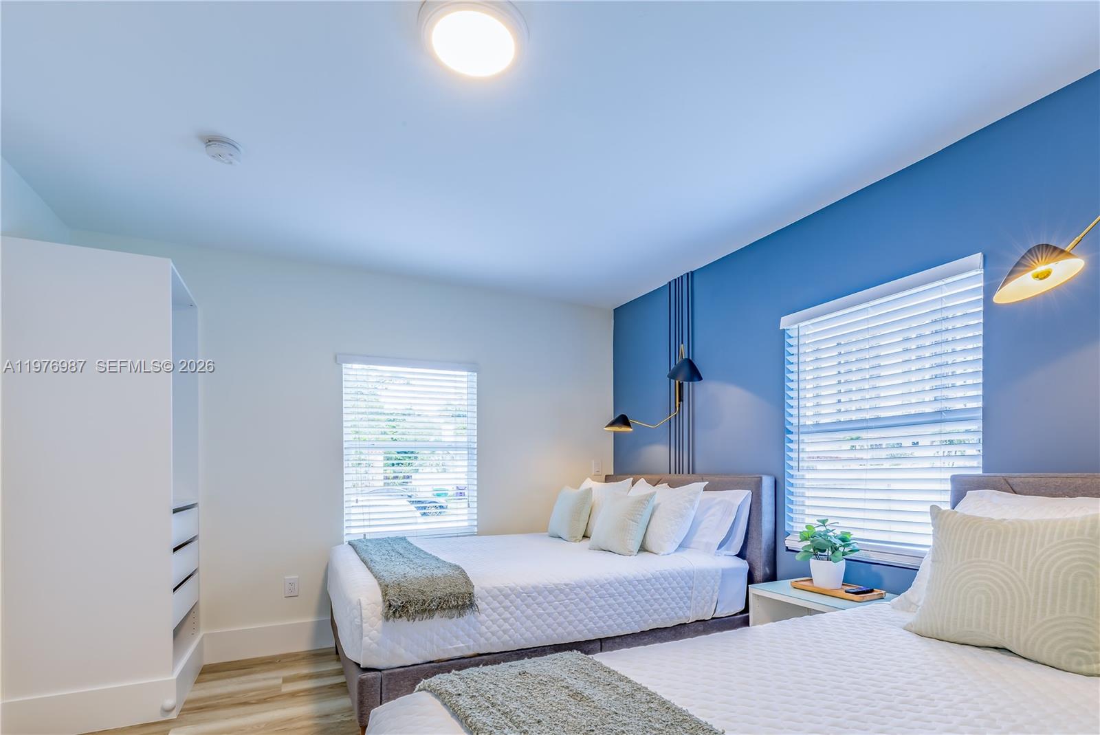 A bedroom features two beds, a blue accent wall, and white window blinds — 1762 NW 15th St, Miami FL 33125, MIAMI, FL