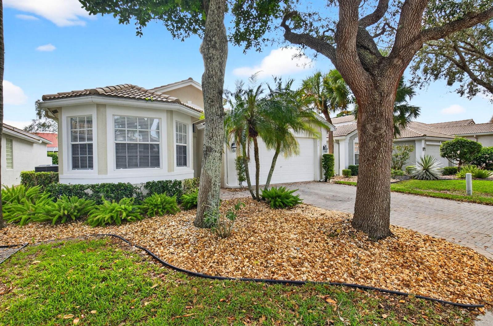 A single-story house with a bay window, a paved driveway, and a gravel front yard — 7232 Morocca Lake Drive, Delray Beach FL 33446, DELRAY BEACH, FL