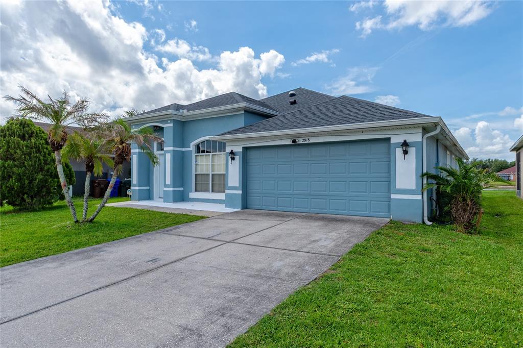 A blue single-story house with a two-car garage and a concrete driveway — 2818 OCONNELL DRIVE, KISSIMMEE, FL