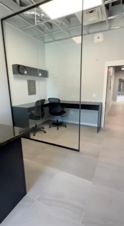 A modern lobby features marble floors, a black staircase, and floor-to-ceiling windows — 4560 W IRLO BRONSON MEMORIAL HIGHWAY UNIT 203, KISSIMMEE, FL