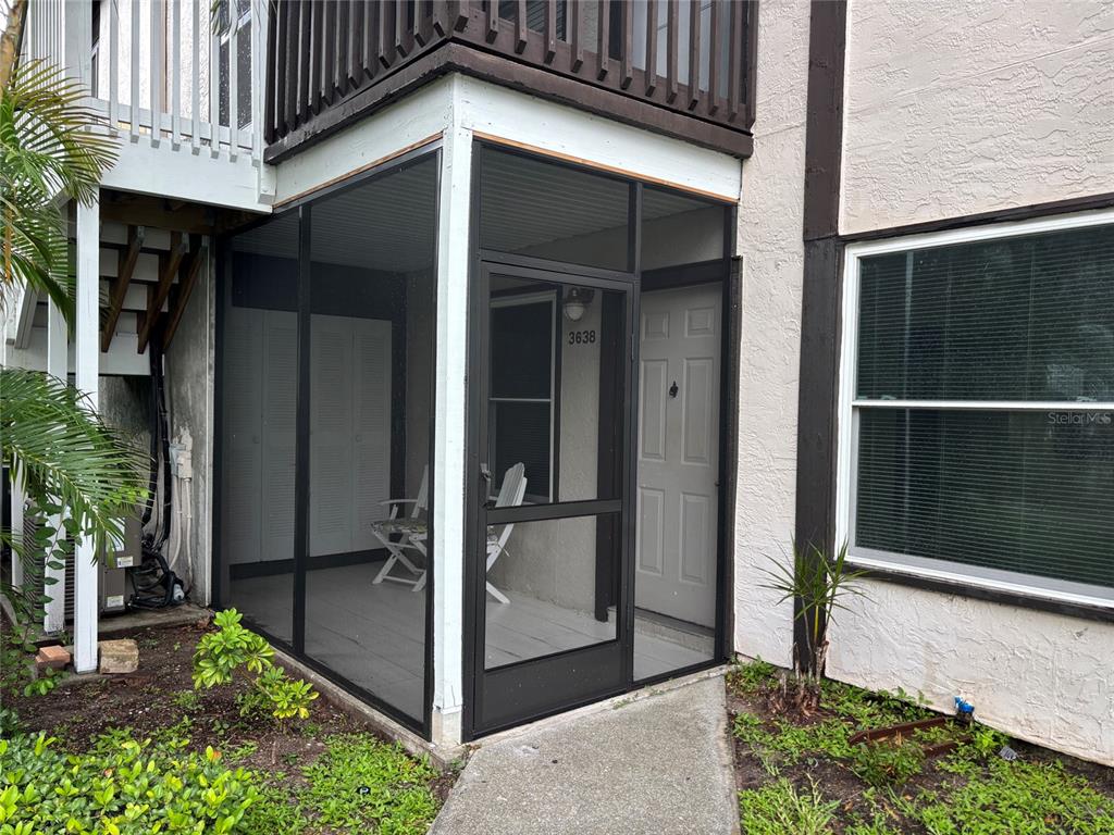 A screened-in porch with a white door and a concrete walkway leads to the entrance — 3638 59TH AVENUE W UNIT 3638, BRADENTON, FL