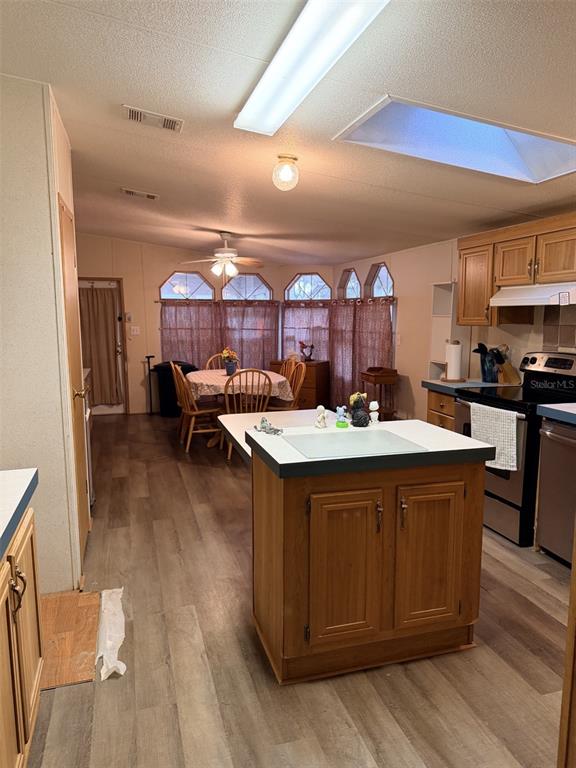 A kitchen with wood cabinets and a center island opens into a dining area — 794 NE 521 STREET, OLD TOWN, FL