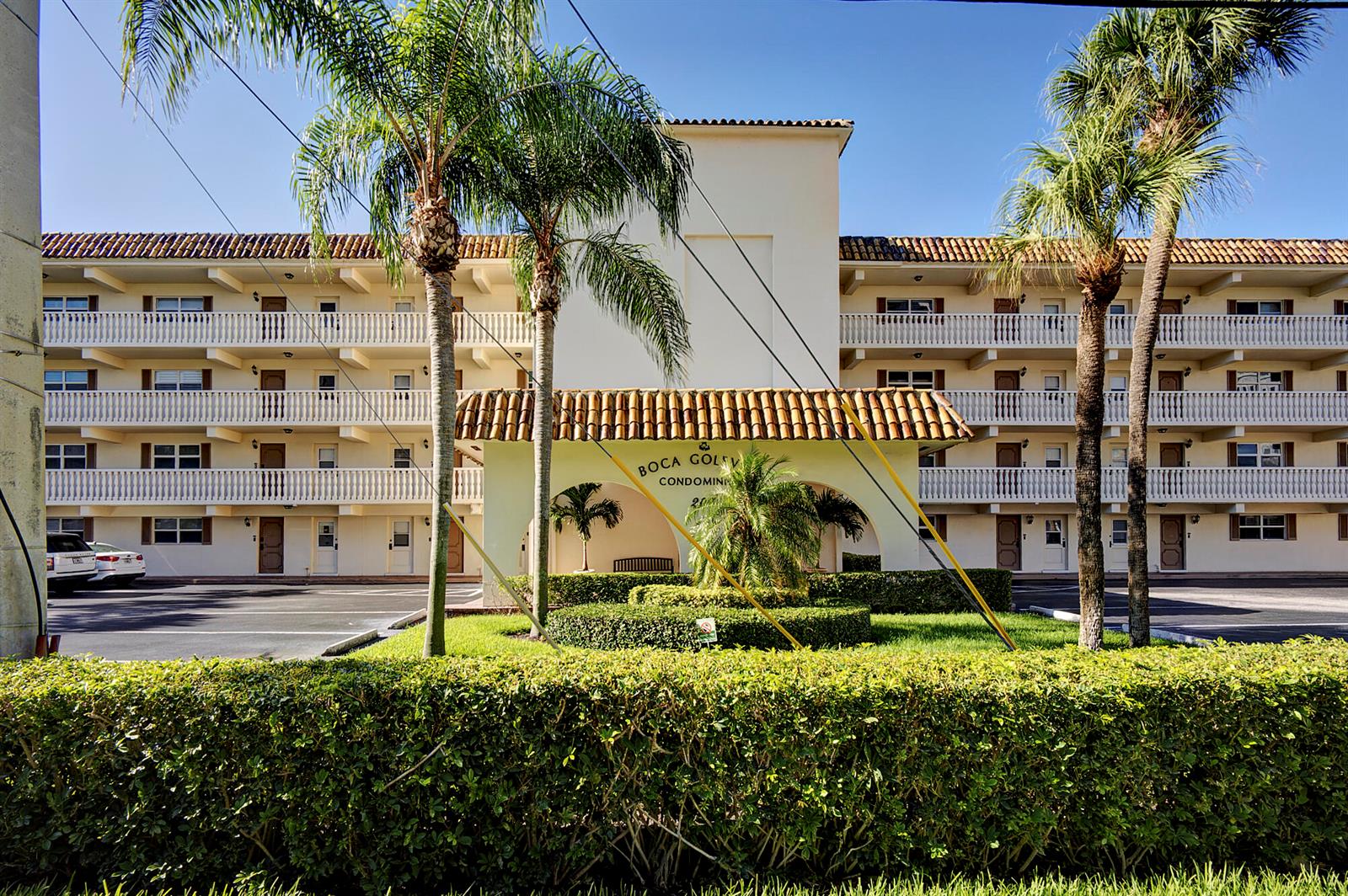 A multi-story apartment building with a tiled roof, balconies, and palm trees in the foreground — 200 E Royal Palm Road # 2110, Boca Raton FL 33432, BOCA RATON, FL