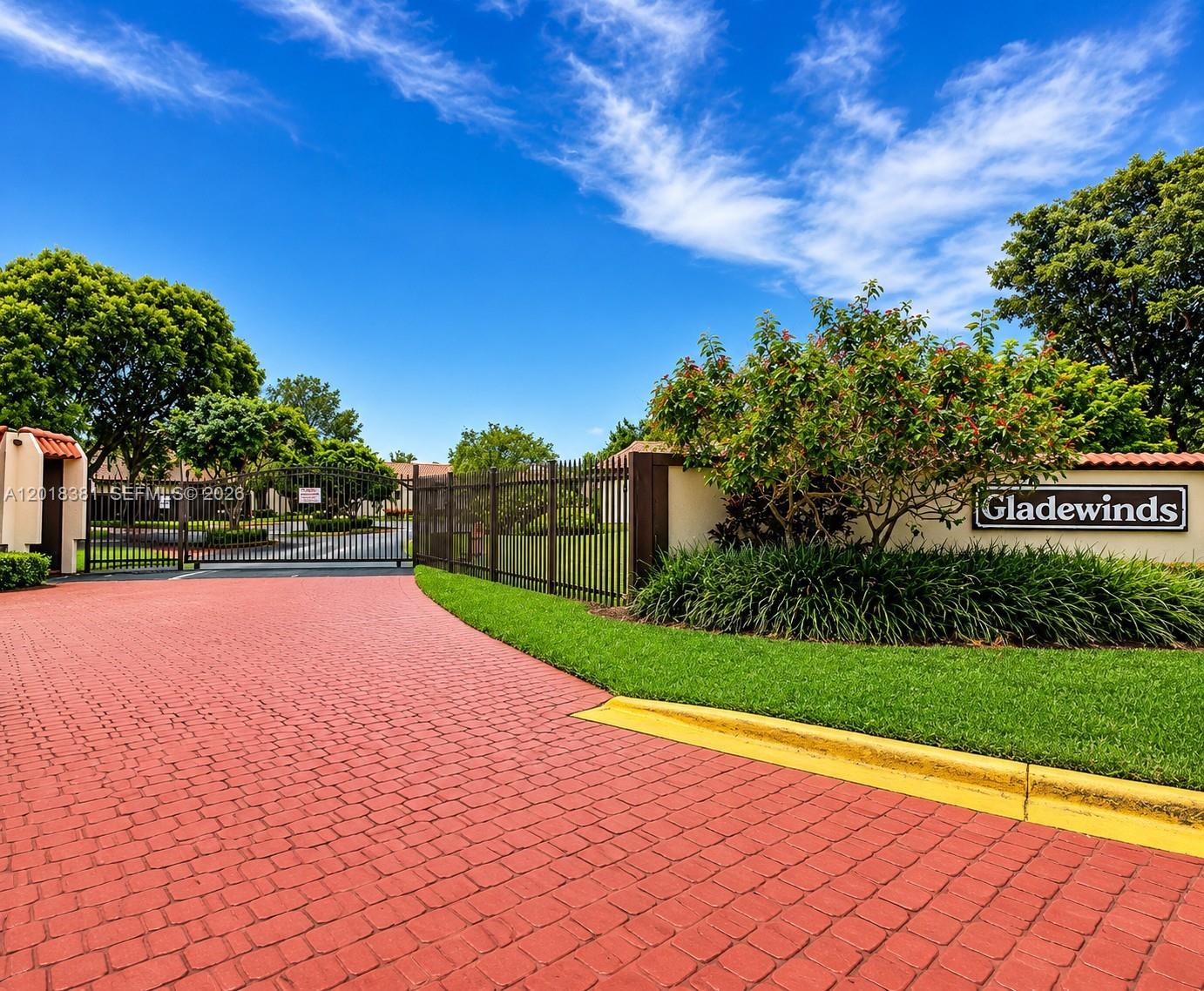 A red brick driveway leads to a gated entrance with a Gladewinds community sign — 9123 SW 112th Ct, Miami FL 33176, MIAMI, FL