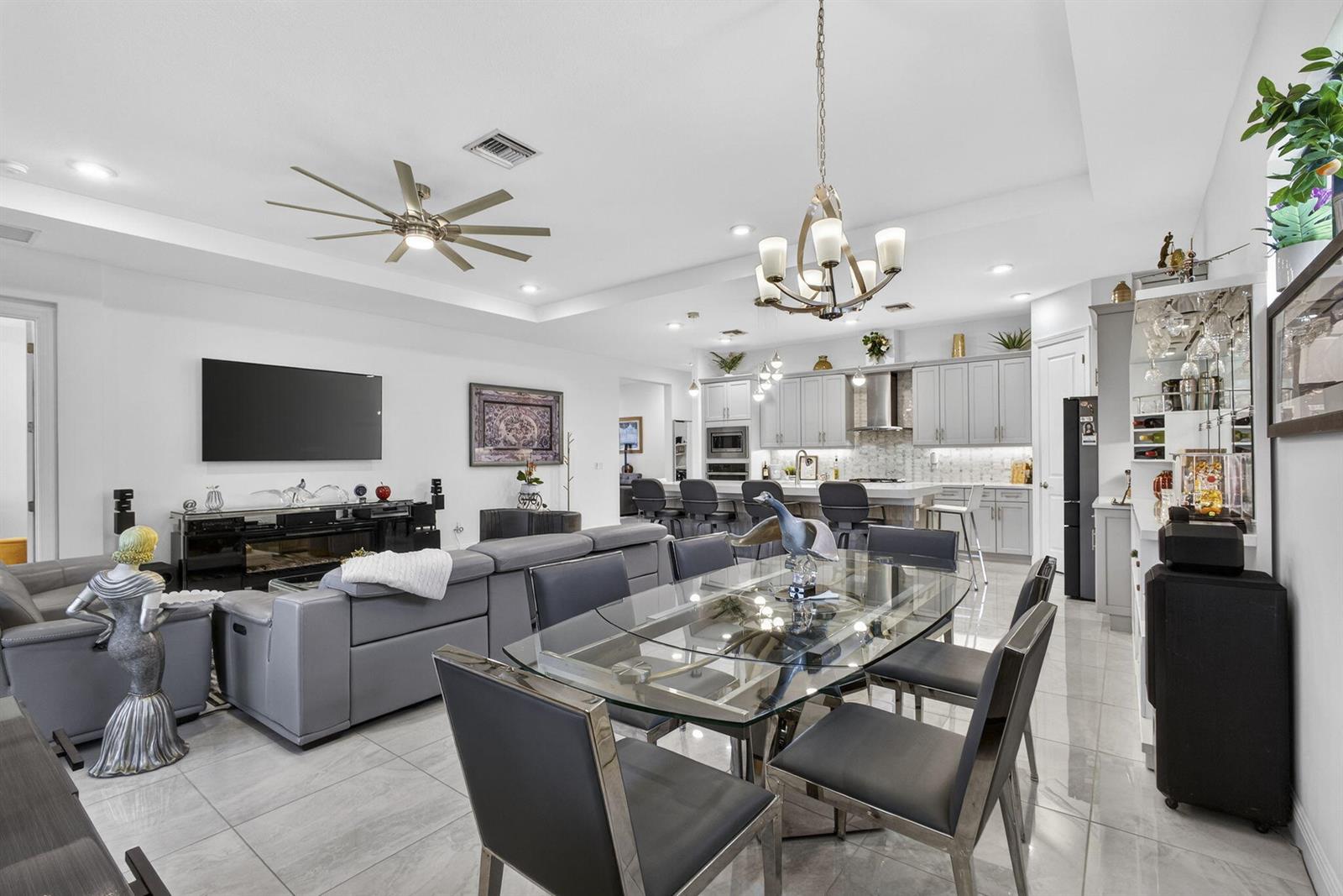 A living room features a large sectional sofa, glass coffee table, and sliding glass doors — 5492 St Armands Way, Westlake FL 33470, WESTLAKE, FL