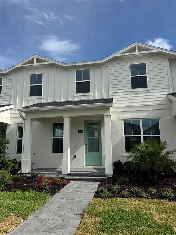 A two-story house features white siding, a light green front door, and a paved walkway — 1860 CROWNCREST DRIVE, APOPKA, FL
