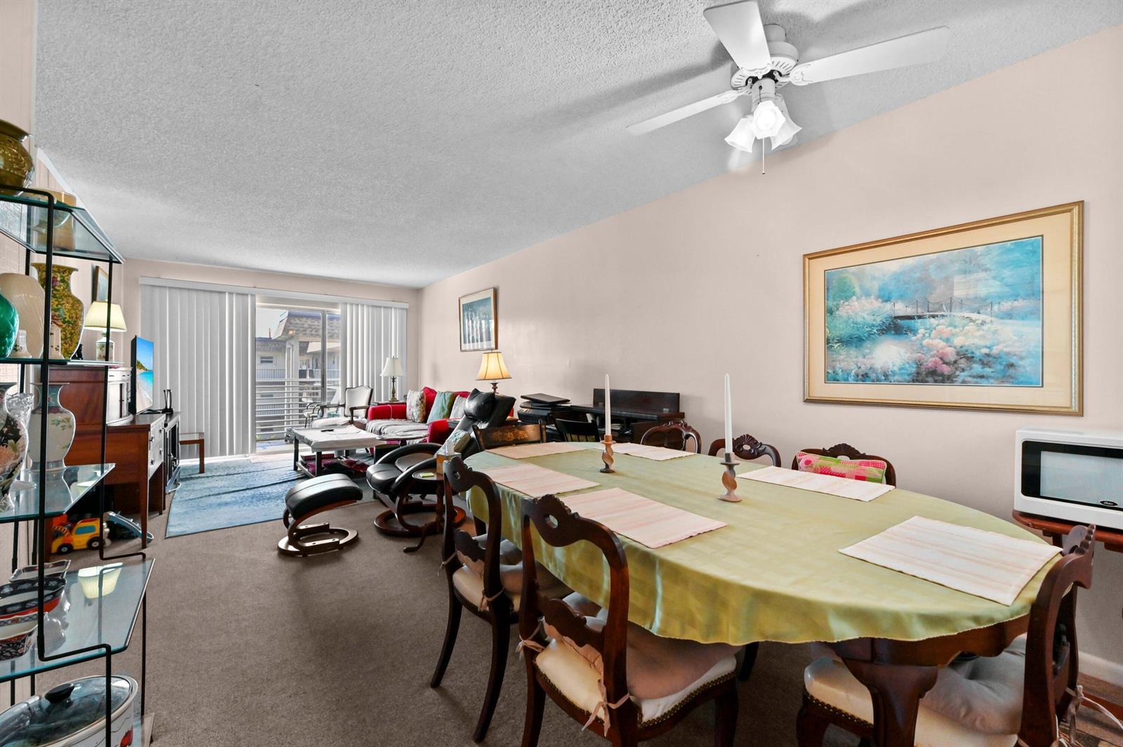 A dining area with a wooden table and chairs sits in front of a living room — 721 Lori Drive # 313, Palm Springs FL 33461, PALM SPRINGS, FL