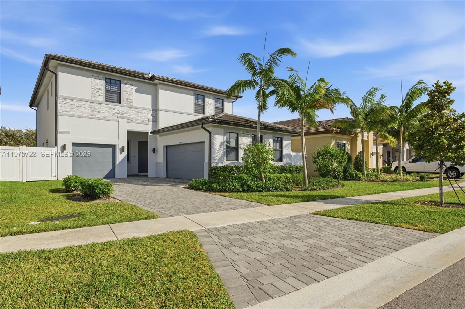 A two-story house with a gray garage, stone accents, and palm trees in the front yard — 4409 SW 173rd Ave, Miramar FL 33029, MIRAMAR, FL