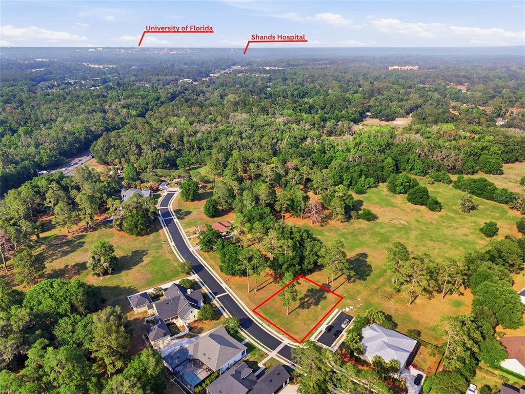 An aerial view shows a vacant residential lot outlined in red within a wooded neighborhood — 6723 SW 40TH TERRACE, GAINESVILLE, FL