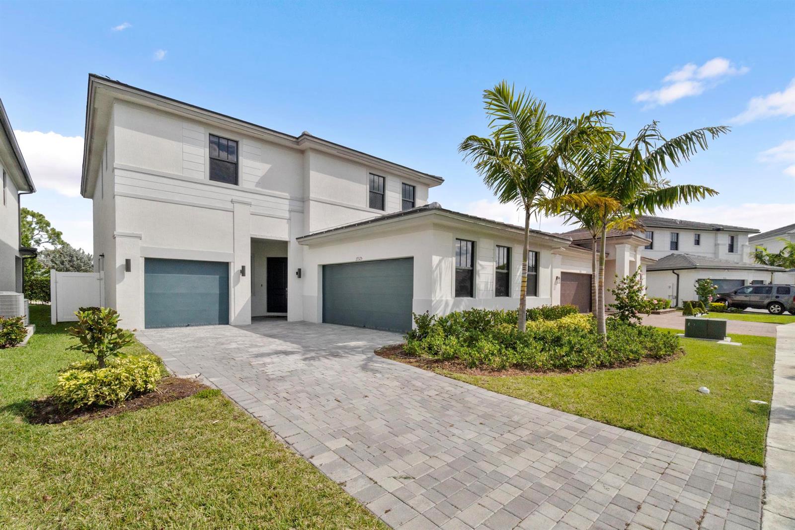 A two-story house with a paved driveway, two garage doors, and palm trees in front — 17325 SW 41 Street, Miramar FL 33029, MIRAMAR, FL