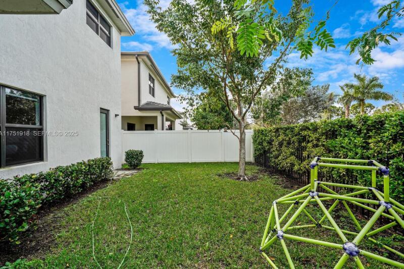 A backyard features a green climbing dome, a white privacy fence, and a tree — 17325 SW 41 Street, Miramar FL 33029, MIRAMAR, FL
