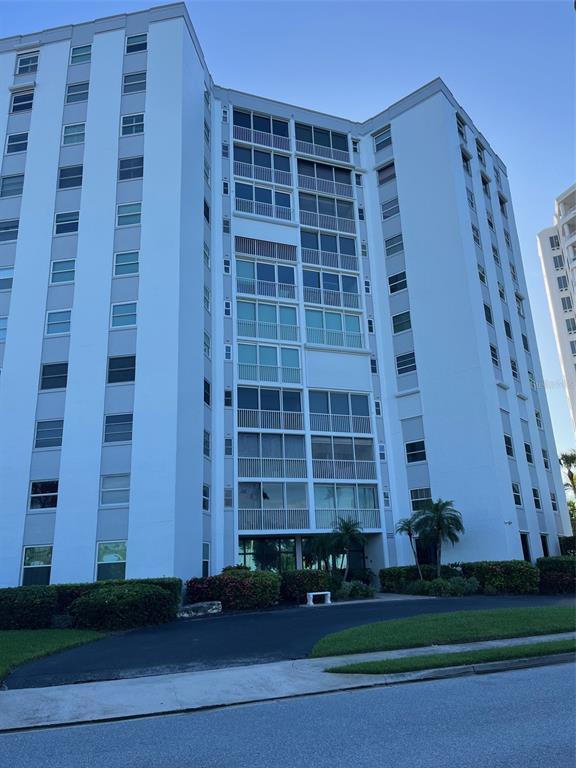 A tall, white multi-story residential apartment building with screened balconies and surrounding landscaping — 435 S GULFSTREAM AVENUE UNIT 206, SARASOTA, FL