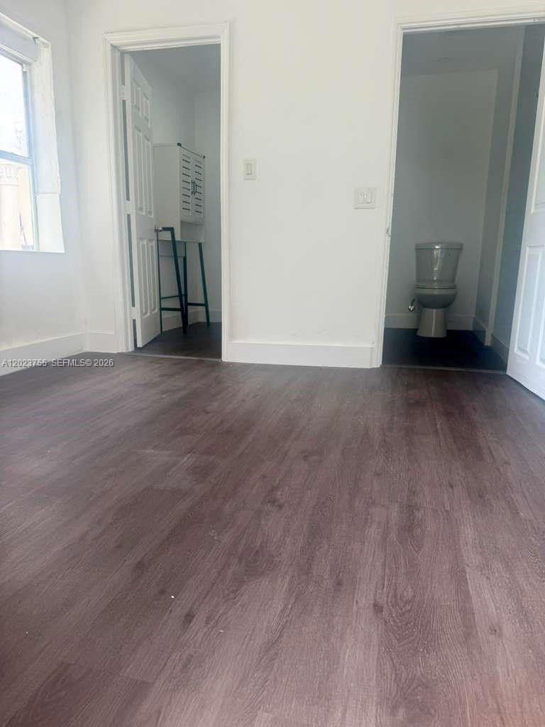 A room with wood-look flooring features two doorways leading to a bathroom and closet — 6026 SW 27th St # 1, Miramar FL 33023, MIRAMAR, FL