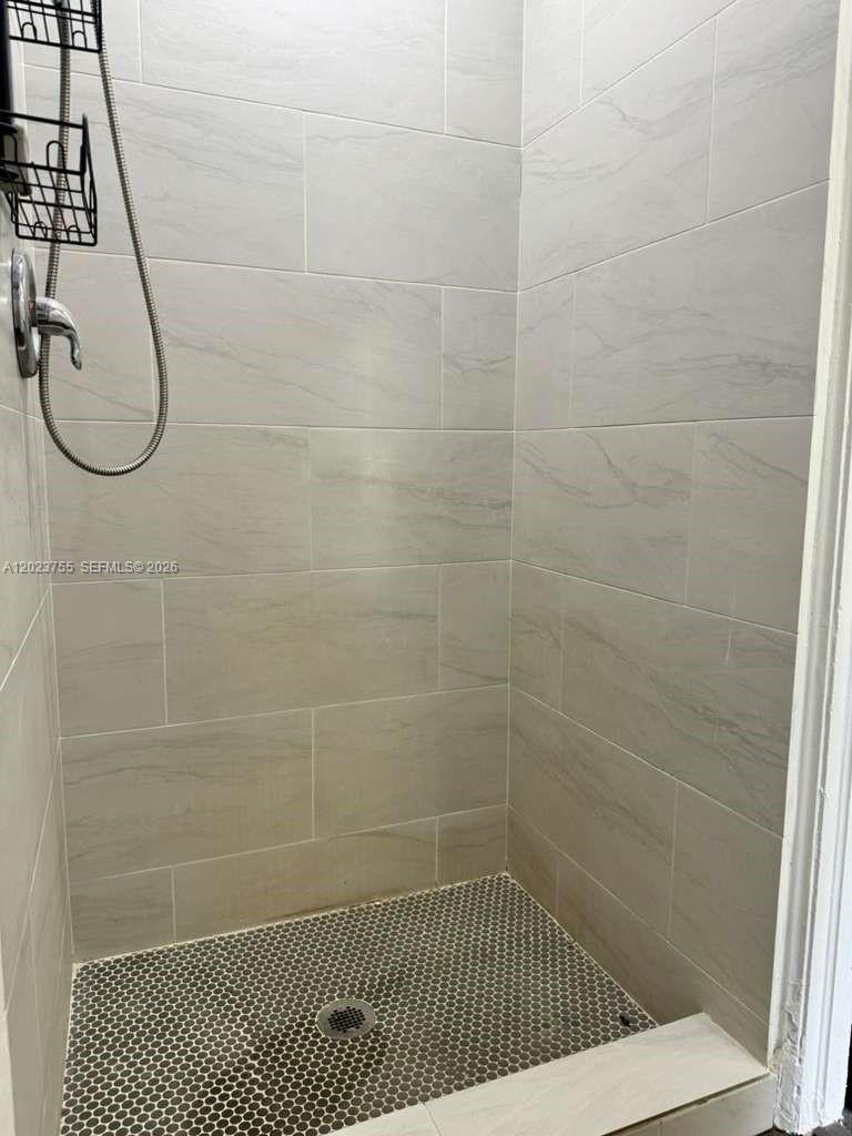 A walk-in shower features light-colored rectangular wall tiles and a dark hexagonal tile floor — 6026 SW 27th St # 1, Miramar FL 33023, MIRAMAR, FL