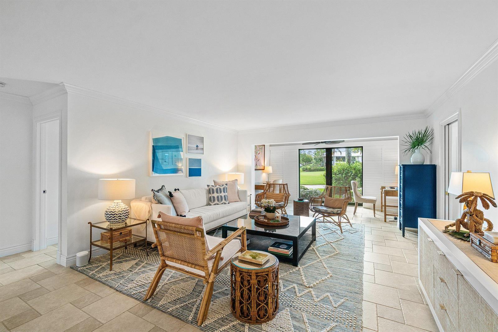 A bright living room features a white sofa, rattan chairs, a patterned rug, and tile flooring — 3944 Quail Ridge Dr Drive N, Boynton Beach FL 33436, BOYNTON BEACH, FL