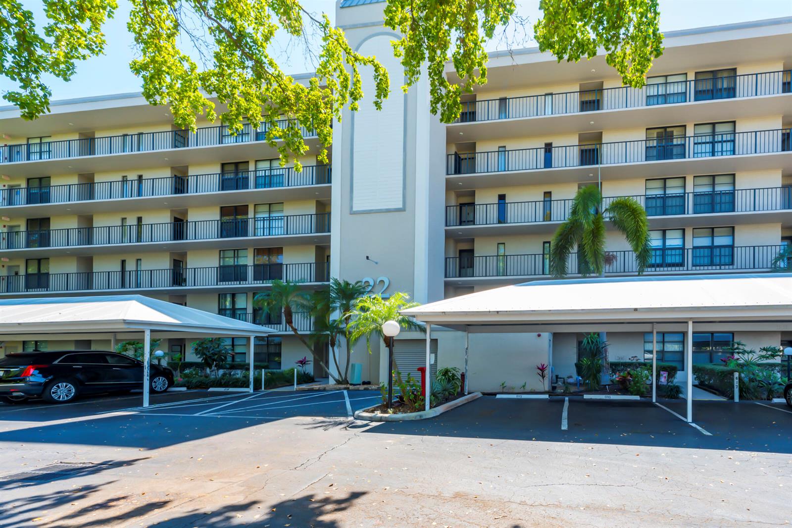 A multi-story apartment building with covered parking spaces in the foreground — 22 Royal Palm Way # 606, Boca Raton FL 33432, BOCA RATON, FL