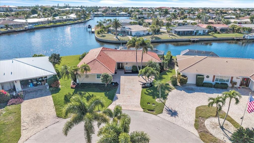 An aerial view shows a house with a red tile roof near a canal — 1109 APPIAN DRIVE, PUNTA GORDA, FL