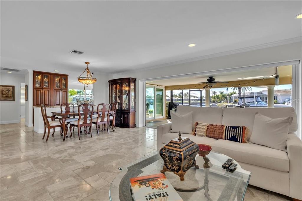 A living and dining area with tile floors, a white sofa, and a glass-topped table — 1109 APPIAN DRIVE, PUNTA GORDA, FL