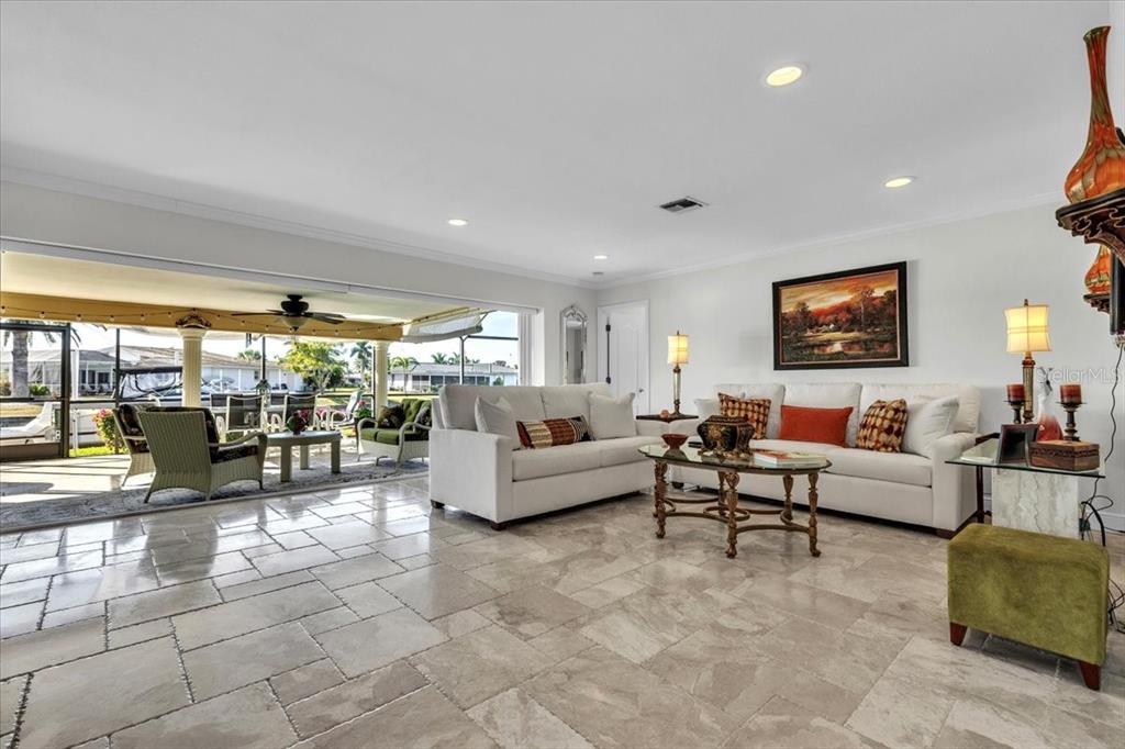 A living room with light tile floors opens to a covered patio with outdoor furniture — 1109 APPIAN DRIVE, PUNTA GORDA, FL