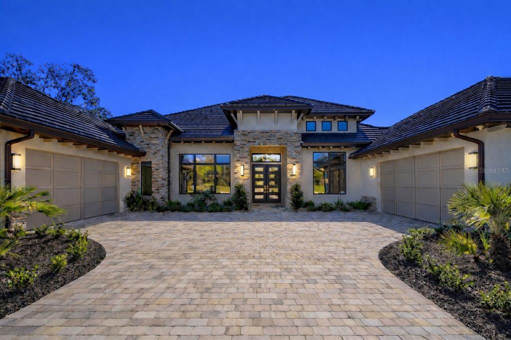 A single-story house with a stone facade, dark tile roof, and a paved circular driveway — 1861 ADRIAN CREEK BLVD, PORT ORANGE, FL