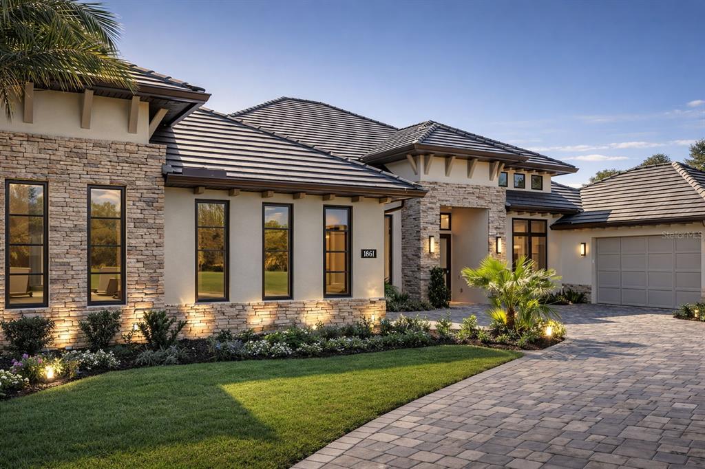 A single-story house with a stone facade, dark tile roof, and a paved driveway — 1861 ADRIAN CREEK BLVD, PORT ORANGE, FL