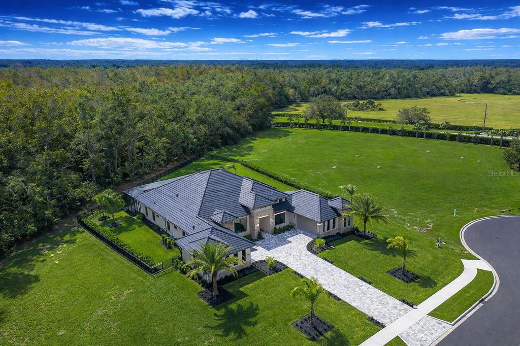 An aerial view of a single-story house with a dark roof and paved driveway — 1861 ADRIAN CREEK BLVD, PORT ORANGE, FL