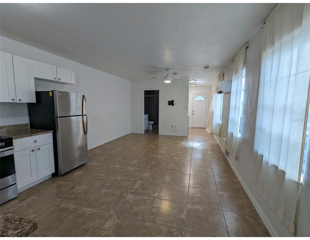 A kitchen and living area with tile floors, white cabinets, and stainless steel appliances — 411 S ALBANY AVENUE UNIT 3, TAMPA, FL
