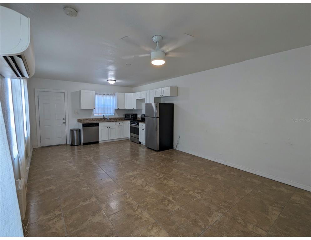 A kitchen with white cabinets, stainless steel appliances, and tile flooring in an open room — 411 S ALBANY AVENUE UNIT 3, TAMPA, FL
