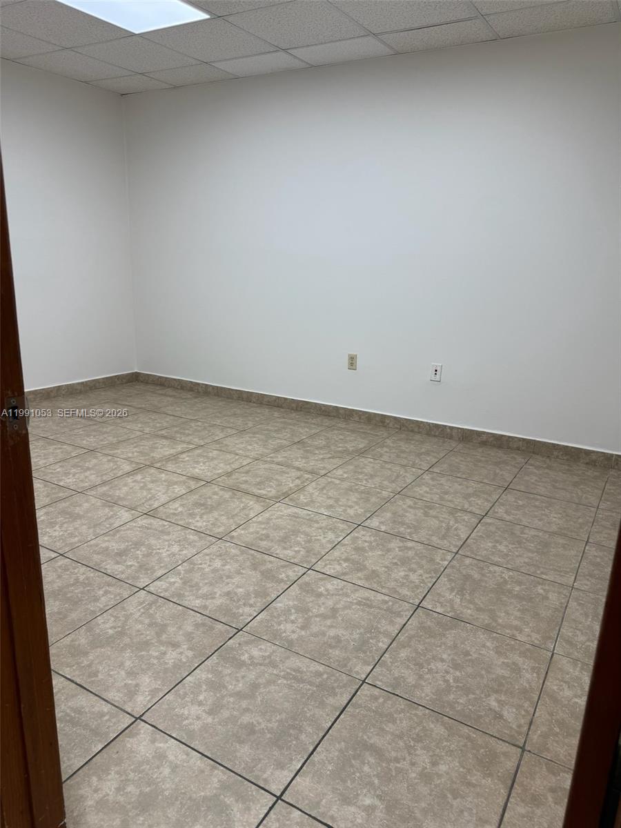 An empty office room features light-colored tile flooring, white walls, and a drop ceiling — 6995 NW 82nd Ave # 45, Medley FL 33166, MEDLEY, FL