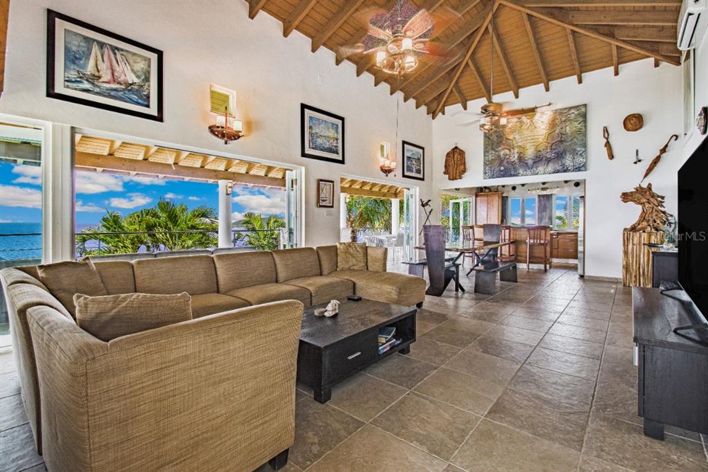 A spacious living room with a vaulted wood ceiling, tile floors, and ocean views — BO FLAMENCO LAS QUINTAS SOLAR 15 UNIT Sec La Quintas Solar 15, CULEBRA, PR