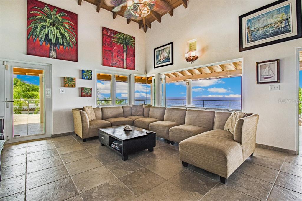 A living room with a large sectional sofa, tile floors, and a view of the ocean — BO FLAMENCO LAS QUINTAS SOLAR 15 UNIT Sec La Quintas Solar 15, CULEBRA, PR
