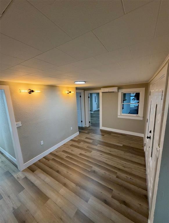 An interior view shows a room with wood-look flooring, wall sconces, and a mini-split unit — 1221 E DR MARTIN LUTHER KING JR BOULEVARD, TAMPA, FL