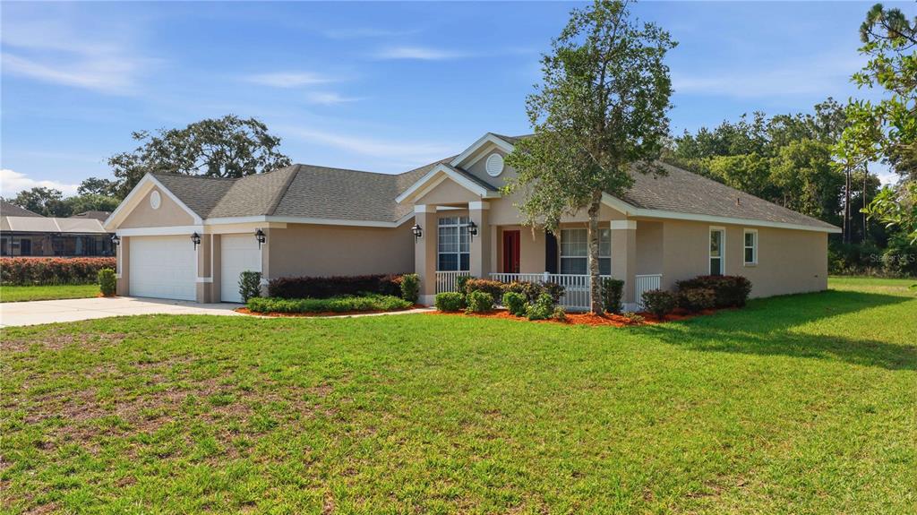 A single-story beige house with a two-car garage and a front porch — 334 LAKE DRIVE, OCALA, FL
