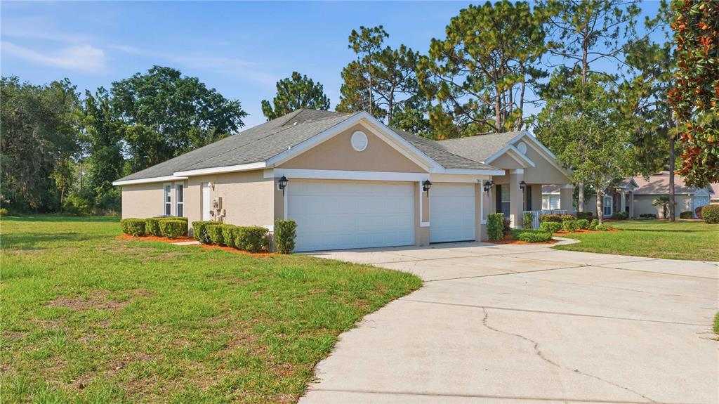 A beige single-story house with a two-car garage and a concrete driveway — 334 LAKE DRIVE, OCALA, FL