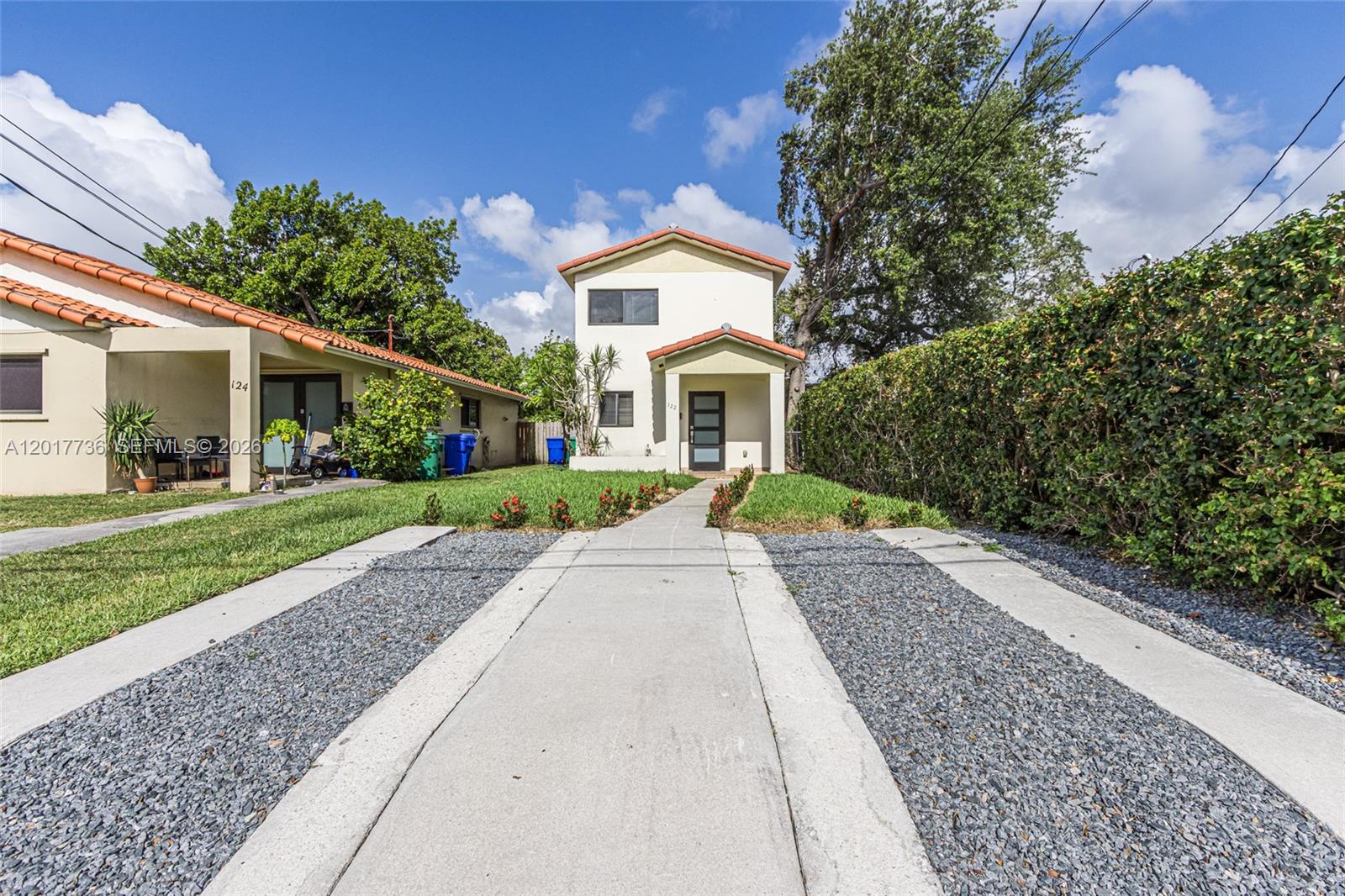 A two-story house with a gravel driveway and a concrete walkway leading to the entrance — 122 SW 56th Ave, Miami FL 33134, MIAMI, FL