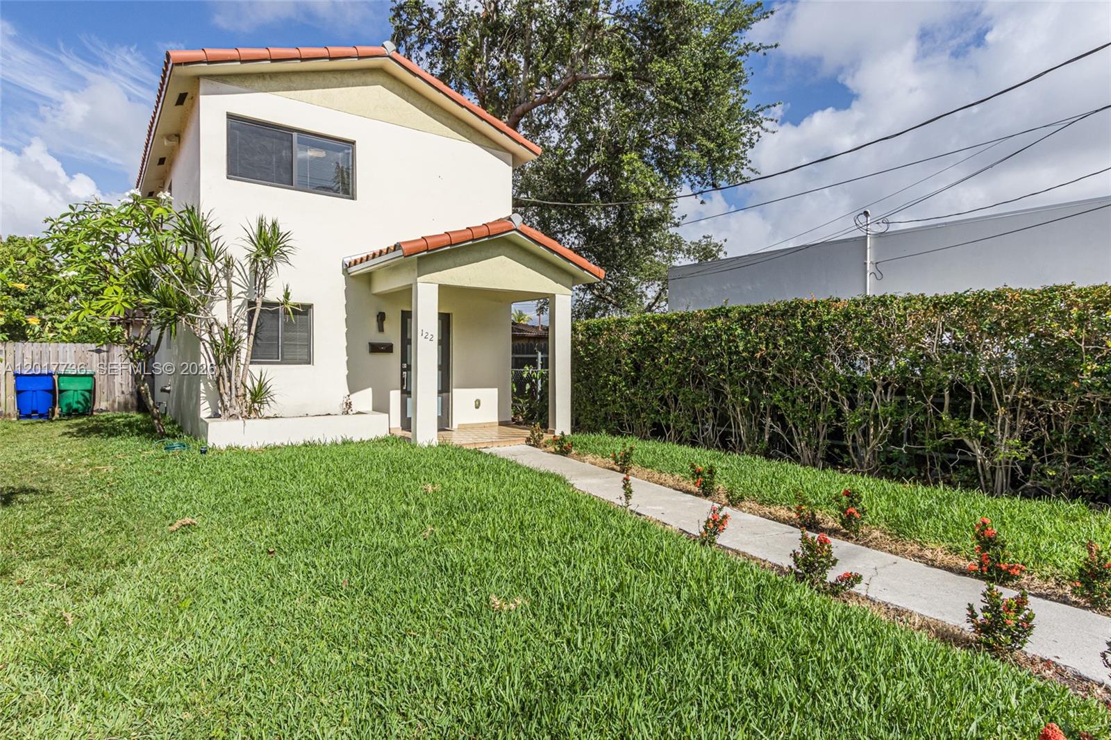 A two-story house with a tiled roof, front porch, and a concrete walkway through grass — 122 SW 56th Ave, Miami FL 33134, MIAMI, FL