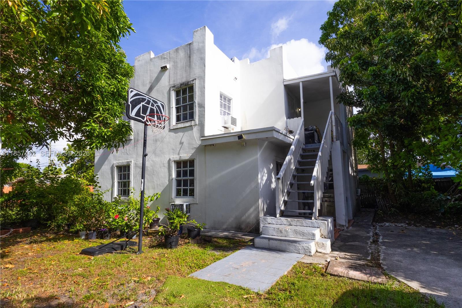 A two-story white stucco building features an exterior staircase leading to an upper-level entrance — 2367 SW 19th St, Miami FL 33145, MIAMI, FL